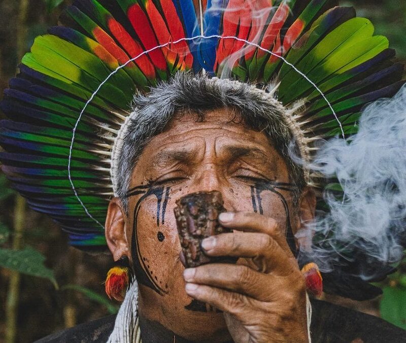 Man in headdress using plant medicine