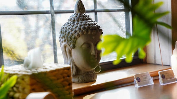 Stone buddha head on bright window sill