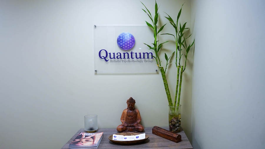 Quantum sign on wall with bamboo and buddha statue