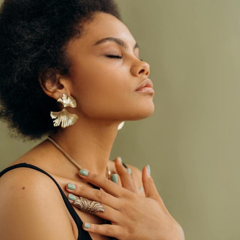 woman with hands over chest breathing with eyes closed