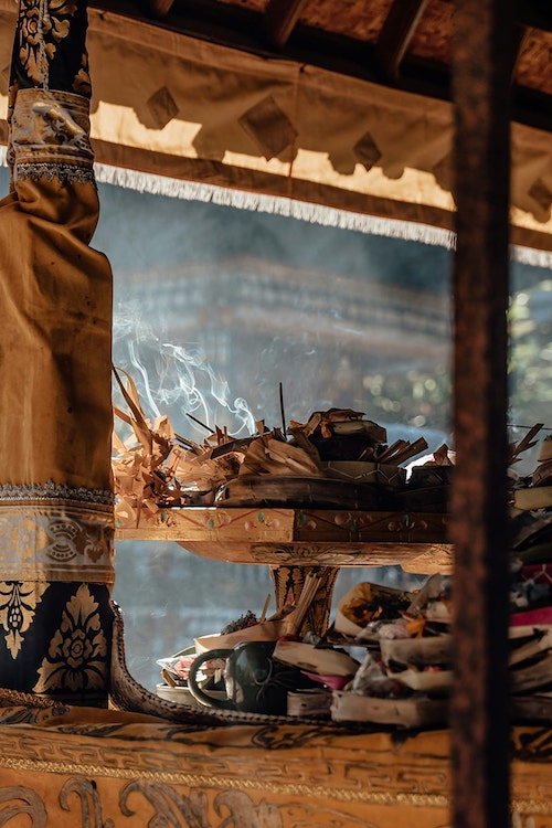 burning leaves and incense on decorative carved stand