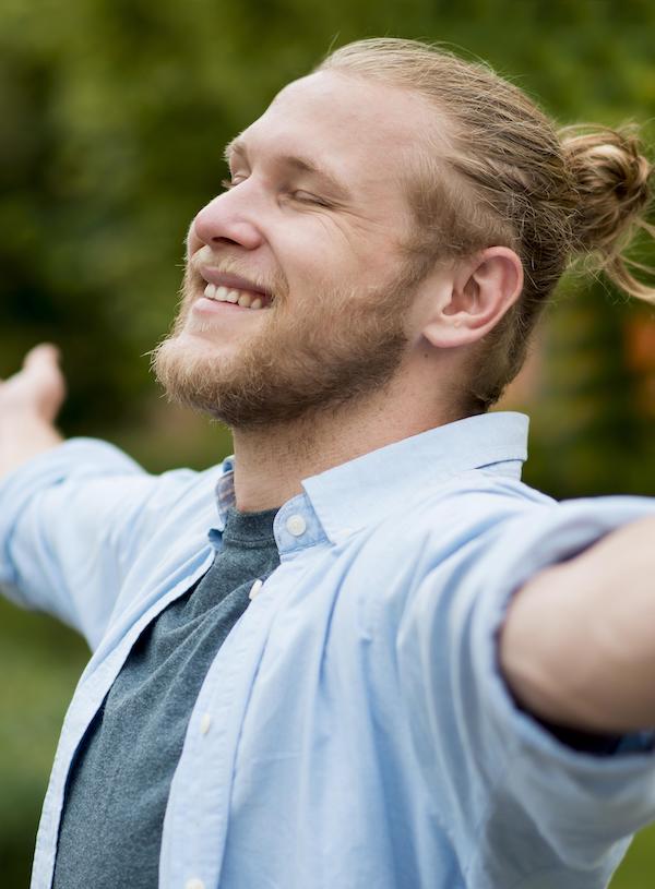 man with arms outstretched smiling