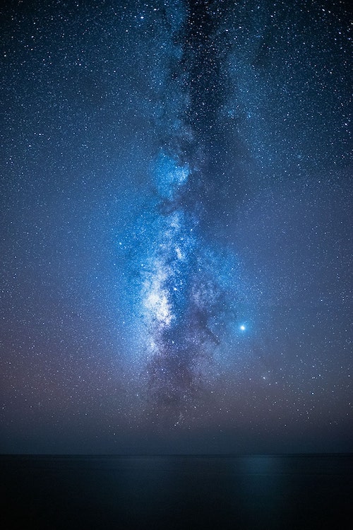 night sky with milky way over calm water