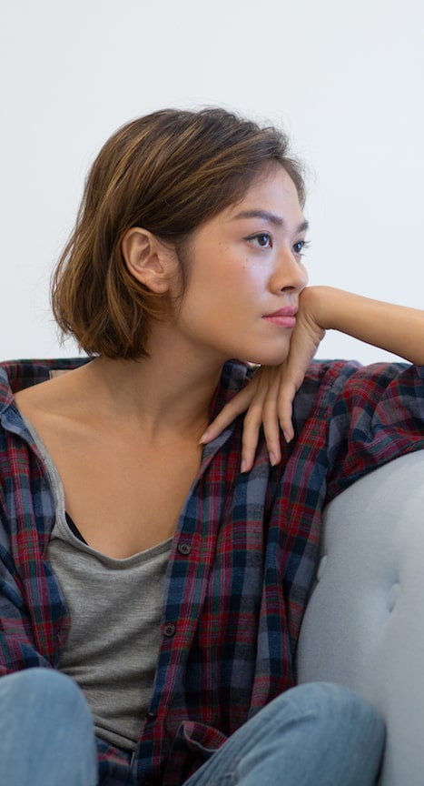 woman sitting on sofa looking pensive