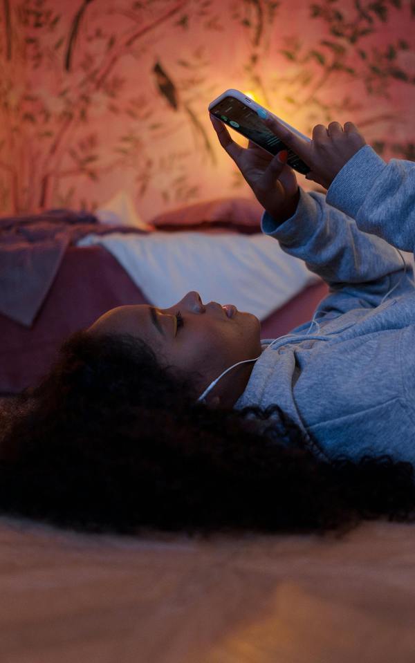 teenage girl lying down using phone