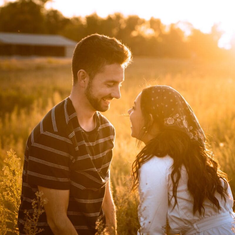 couple-looking-at-each-other-while-standing-on-the-field