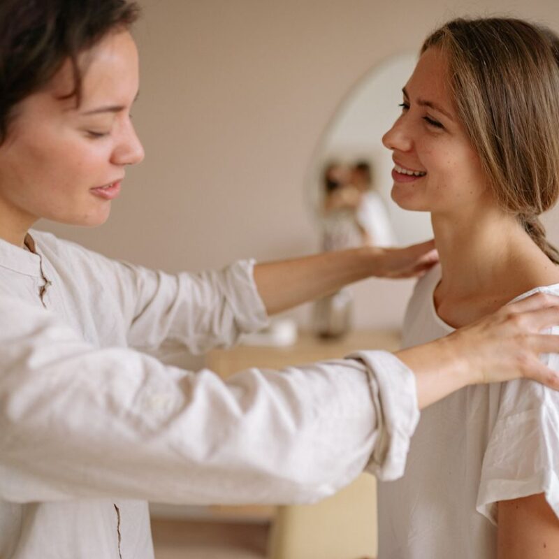 woman-in-white-dress-up-shirt-holding-the-shoulder-of-woman-in-white-t-shirt